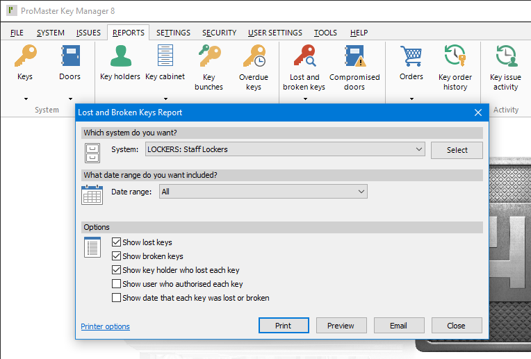 ProMaster Key Manager 8 Lost and Broken Keys Report options window on top of the main ProMaster Key Manager 8 window. The first report option section, “Which system do you want?”, contains a dropdown list to select the “System” and a “Select” button to search for a system. The second option section is “What date range do you want to include?” with a dropdown list for the “Date range” (currently set to “All”) and space around for additional option to be displayed, depending on what is set in the dropdown list. The last section is called “Options” and contains check boxes for enabling the options to “Show lost keys”, “Show broken keys”, Show key holder who lost each key”, “Show user who authorised each key” and “Show date that each key was lost or broken”. In the bottom left corner, there is a “Printer options” link, and in the bottom right, there are 4 buttons; “Print”, “Preview”, “Email” and “Cancel”.